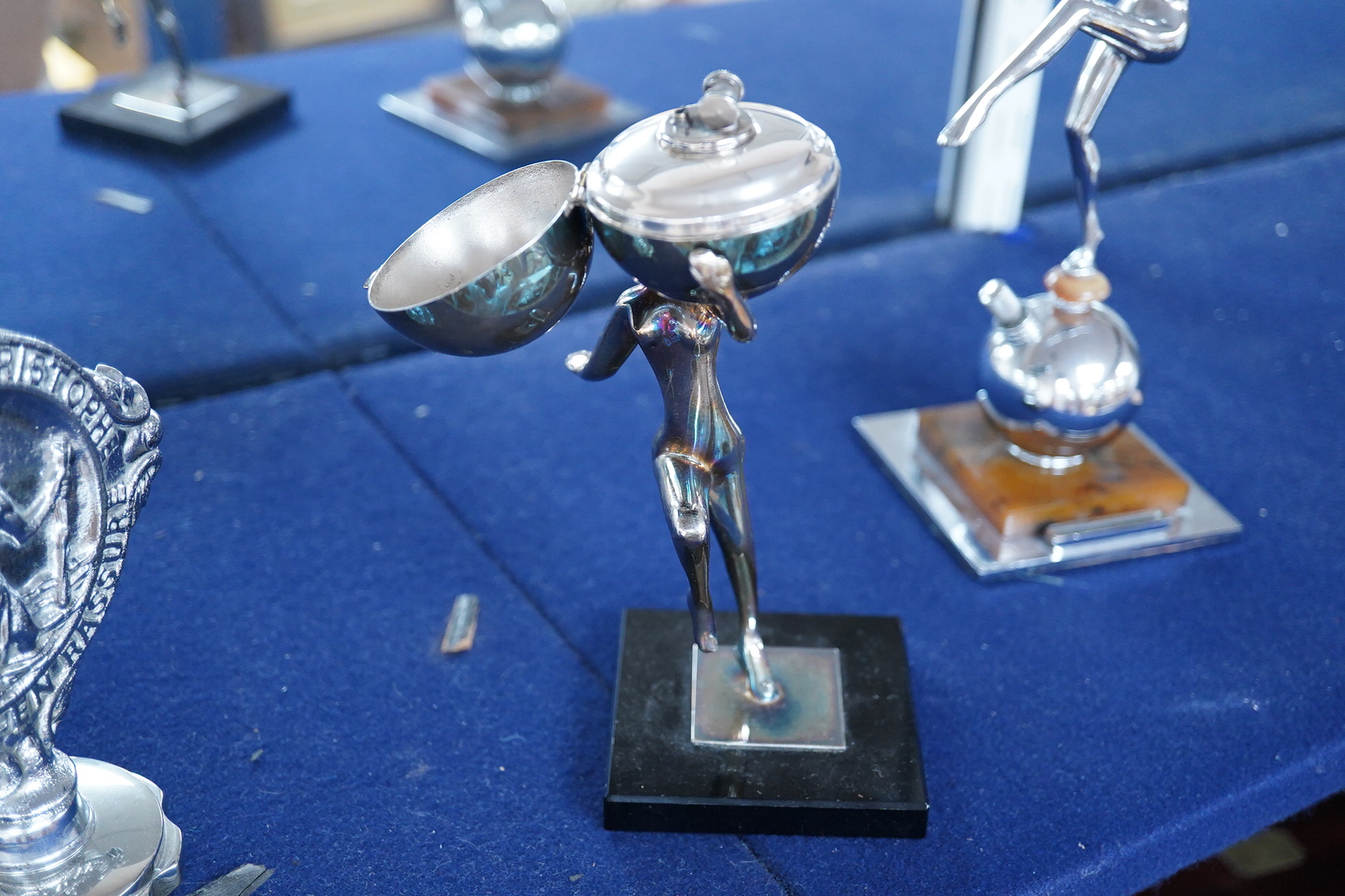 Five chrome and brass car mascots, including a knight, a policeman, a figure of Mercury, etc. together with two Art Deco table lighters as female figures, and an ashtray with the figure of a blacksmith (8)